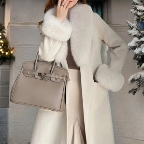 Luxury beige winter coat with a faux fur collar, made from designer wool. The overcoat features long sleeves and is styled for fashion-forward outerwear. The variant shown is gray and size large.