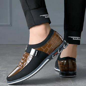 Luxury black leather men's formal shoes featuring a designer checkered pattern, elegantly styled on a person's foot.