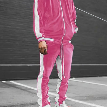 Man wearing a luxury blue velvet tracksuit and pink sneakers, standing on asphalt; the tracksuit includes a stylish jacket and pants, designed for men's sportswear.