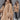 Luxurious women's camel wool cape with faux fur trim, showcasing elegant outerwear style, worn by a model with styled hair and fashionable shoes, highlighting winter fashion.