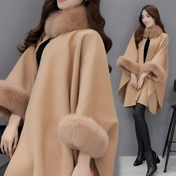 Luxurious women's camel wool cape with faux fur trim, showcasing elegant outerwear style, worn by a model with styled hair and fashionable shoes, highlighting winter fashion.
