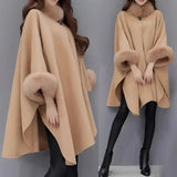 Women's winter cape made from luxury camel wool in a brown color, featuring a faux fur trim. The cape is designed to fit a plus-size 5XL, showcasing elegant outerwear that covers the shoulders and neck area. The garment is crafted to provide warmth and style, ideal for the colder months.
