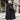Oversized black puffer down jacket with a fur hood, featuring a fashionable design, standing display, and long sleeves.