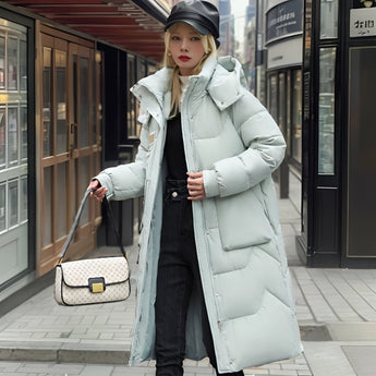 Oversized black puffer down jacket featuring a luxurious fur-lined hood, showcased in a detailed photograph. The design highlights include a sleek overcoat style, prominent sleeves, and a distinctive collar, exuding sophistication and warmth.
