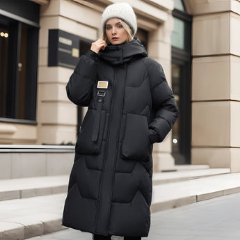 
A stylish and oversized black puffer down jacket featuring a luxurious fur hood, designed for high fashion. The jacket is being worn by a person standing, emphasizing its fashionable and cozy design, suitable for winter wear. The jacket is in size 3XL.