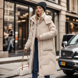 Oversized black puffer jacket with a fur hood, worn by a person standing near a car, showcasing its luxurious and fashionable design.