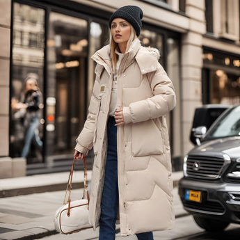 Oversized black puffer jacket with a fur hood, worn by a person standing near a car, showcasing its luxurious and fashionable design.