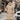 Oversized black puffer down jacket with fur hood in khaki color, displayed on a mannequin, styled with an open front showcasing its luxurious design.