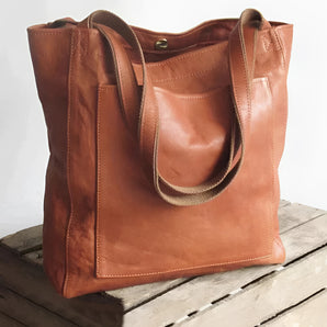 Brown luxury designer leather tote bag in a vintage style, featuring a rectangular shape and shoulder straps, suitable for use as a handbag or hobo bag.