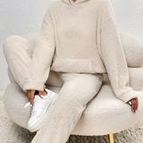 Luxury fleece loungewear set in plush beige, featuring a cozy teddy texture. The outfit includes a top with long sleeves and a collar, paired with comfortable bottoms designed to fit snugly around the waist and thigh.