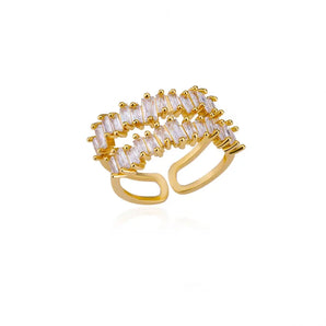 Luxury gold baguette diamond statement ring on a hand, featuring a circular design with adjustable band, showcasing high-end designer jewelry.