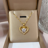 Luxury gold heart pendant necklace with diamond crystal charm on a delicate chain, shown as a romantic gift.