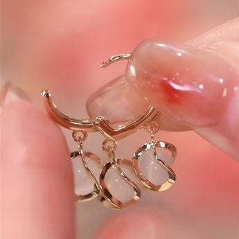 Luxury gold hoop earrings with clear gemstone accents in a vintage box.