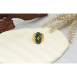 Luxury green gemstone ring with textured 18K gold band by YA-CHAN, elegantly displayed on a white surface.