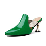 Elegant luxury green mules with a unique metallic heel, set on a wooden floor, showcasing a chic designer slip-on style perfect for fashion-forward individuals.