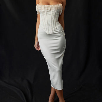 Luxury ivory embroidered bridal gown with a beaded corset, featuring a fitted sheath silhouette, delicate sleeves, and intricate detailing around the waist. The model is styled with her hair down, showcasing the elegant neckline and craftsmanship of the gown.