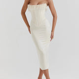 Luxury ivory bridal gown with intricate embroidery and a beaded corset, featuring a flowing one-piece design. The gown highlights the shoulders and neck, complementing the bride's hair and overall elegance.