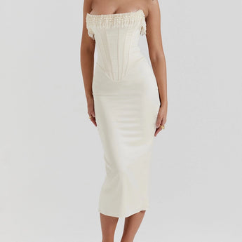 Luxury ivory embroidered bridal gown featuring an intricately beaded corset, showcasing a sheath dress design with elegant shoulder and neck detailing. The gown is modeled on a human figure, highlighting the sophisticated craftsmanship and graceful fit.