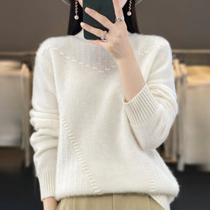 Luxury ivory wool sweater with pearl detailing, featuring a chic knit design. The sweater has long sleeves, a round neckline, and is displayed in size XL.