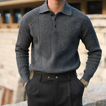 Luxury men's outfit featuring a beige knit polo sweater with a neatly tailored collar and a pair of vintage pleated trousers in a sophisticated gray tone, creating a classic and elegant look.