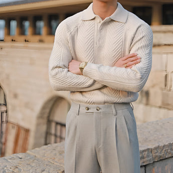 Luxurious men's outfit featuring a beige knit polo sweater paired with vintage pleated trousers in a neutral color, showcasing a sophisticated style.