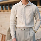 Luxury men's beige knit polo sweater paired with vintage pleated trousers, showcasing elegant outerwear with a collared neckline and long sleeves. The ensemble highlights a sophisticated style with attention to the waist and elbow details.