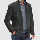 Tan suede blazer for men, featuring a single-breasted design with button closure and a notched collar. Styled over a gray dress shirt with long sleeves, the blazer coordinates elegantly with the gray color scheme.