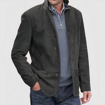 Tan suede blazer for men, featuring a single-breasted design with button closure and a notched collar. Styled over a gray dress shirt with long sleeves, the blazer coordinates elegantly with the gray color scheme.