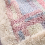 A plush high-pile wool rug in soft pastel shades of purple, pink, and grey, featuring a luxurious and cozy texture.
