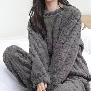 
A luxury plush gray pajama set for women made from cozy fleece material. It features a wrap design with long sleeves and is displayed on a neutral background. The set is in the color Nero and is available in one size.