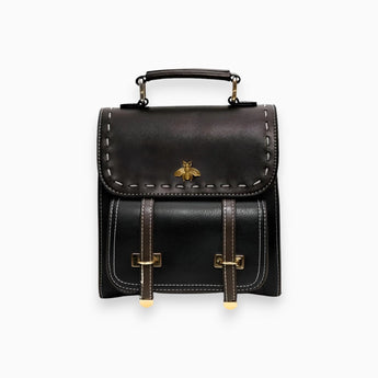Luxury two-tone leather satchel in nero, featuring a rectangular shape with a studded flap and metal accents, equipped with a strap for easy carrying.