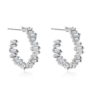 Luxury white gold baguette diamond hoop earrings, elegant bridal jewelry, displayed against a neutral background, showcasing intricate metalwork and sparkling diamonds in a circular design.