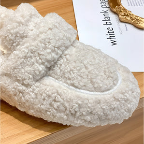 Luxury white sherpa slippers with a plush texture, designed for indoor use with non-slip soles, displayed on a wooden floor.