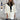 Elegant white wool cape for women, featuring a high neck collar and long sleeves, designed for winter fashion.