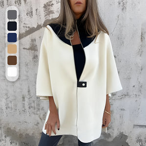 Elegant white wool cape for women, featuring a high neck collar and long sleeves, designed for winter fashion.