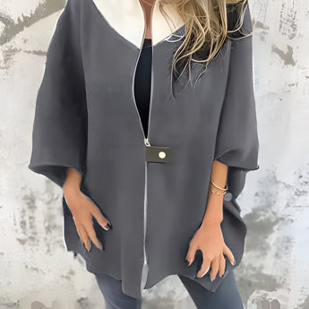 Luxurious white wool cape for women, elegantly draped over shoulders, featuring a sophisticated collar and long sleeves, perfect for winter fashion.