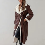 Luxury women's brown leather coat with shearling lining, featuring a tailored collar, long sleeves, and an overcoat design.