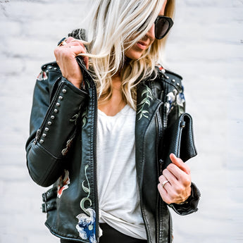 Luxury women's leather jacket featuring intricate floral embroidery, showcasing long sleeves and a stylish waist-length fit.