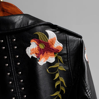 Luxurious women's leather jacket featuring intricate floral embroidery, with long sleeves and a stylish collar, showcasing designer embellishments.