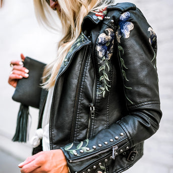 Luxury women's leather jacket with intricate floral embroidery, featuring a stylish design with a collar, long sleeves, and a fitted waist.