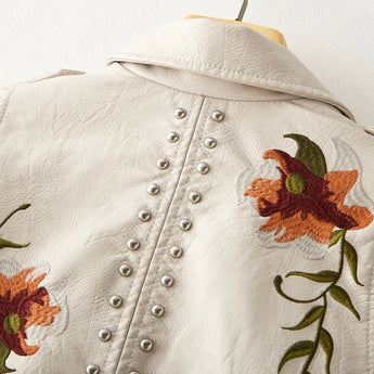 Luxury women's floral embroidered designer leather jacket featuring intricate flower and leaf patterns on soft-textured textile, with a tailored collar and long sleeves, showcasing elegant outerwear craftsmanship.