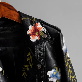 Luxurious women's leather jacket featuring intricate floral embroidery, with a focus on the sleeves and collar, presented in an electric blue hue.