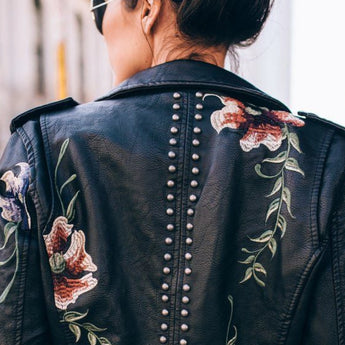 Luxury women's leather jacket with intricate floral embroidery, featuring a stylish collar and long sleeves.