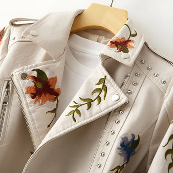 Luxury women's leather jacket featuring intricate floral embroidery on the front and sleeves, with a stylish collar design.