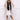 Luxury women's oversized faux fur winter coat in elegant fashion, showcased on a model. The coat features long sleeves and a plush, textured fabric that drapes over the shoulders and down to the waist, providing a stylish and warm outerwear option. The model's hair and legs are also visible, adding to the chic and sophisticated presentation of the coat.