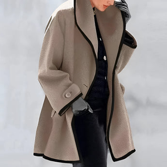 Luxury women's oversized purple wool coat with contrast lining, featuring a stylish collar, long sleeves, and fashionable design elements reminiscent of a trench coat. The coat is displayed on a mannequin, highlighting its elegant silhouette and quality craftsmanship.