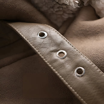 Luxury women's tan suede winter jacket with faux fur collar and long sleeves, displayed on a wooden background.