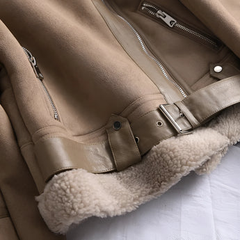 Luxurious women's tan suede faux fur winter jacket showcasing a plush faux fur collar and cuffs, with a stylish beige suede exterior. The jacket is worn by a model, highlighting its full-length sleeves and tailored fit.