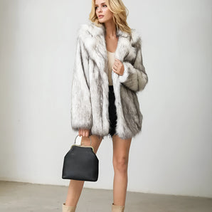 Luxurious women's faux fur coat in white and gray, featuring a stylish collar and long sleeves, perfect for winter fashion.