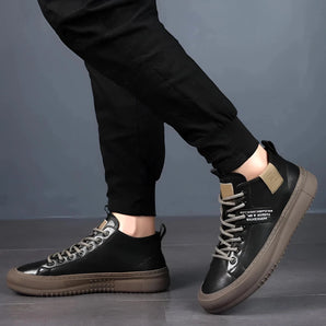 Men's all-black leather low-top sneakers worn with denim jeans, showcasing stylish urban footwear.